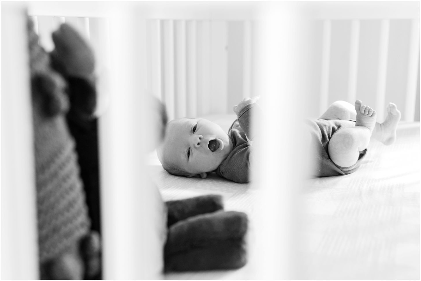 newborn yawning in crib, black and white