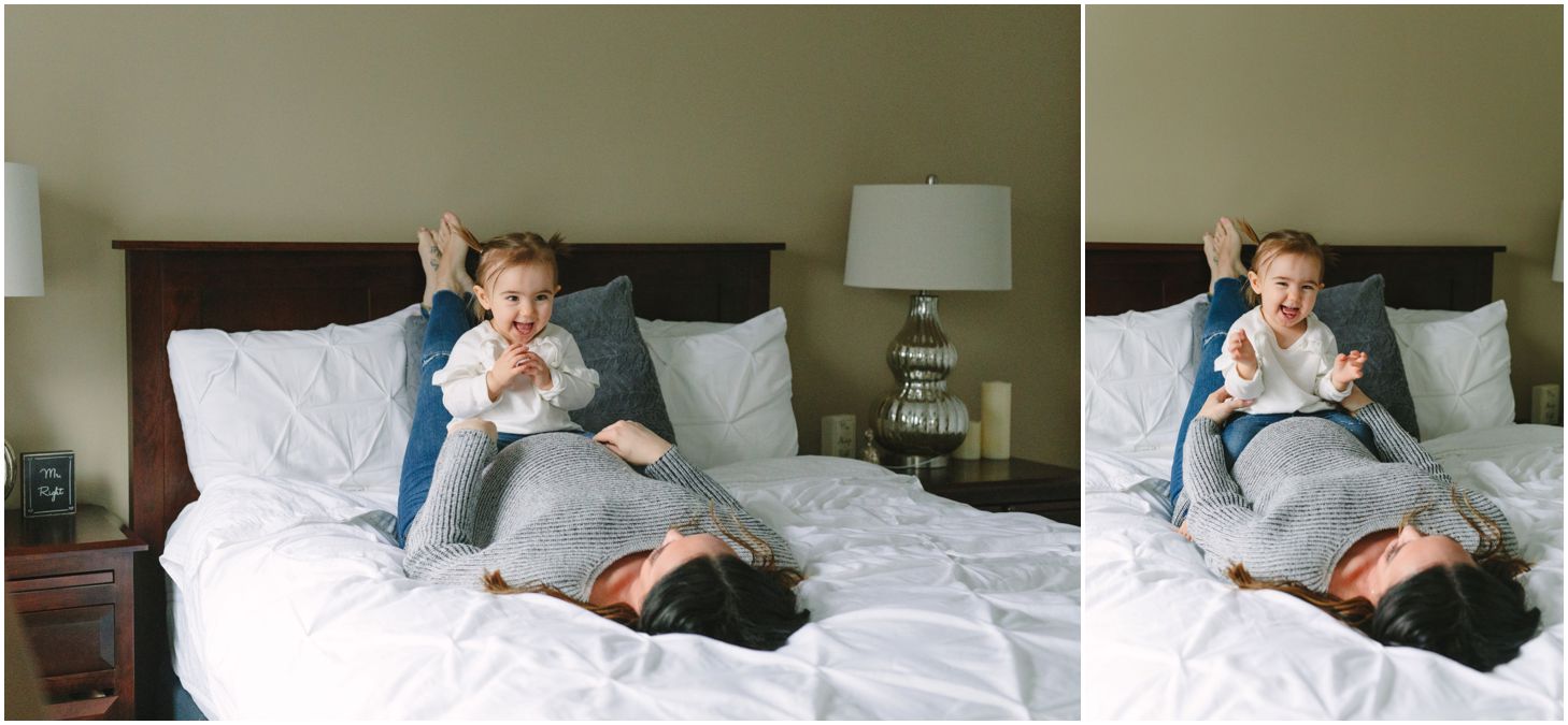 mom and little girl snuggle up together on a white bed