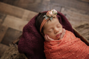 newborn baby girl in coral and burgundy with floral headband