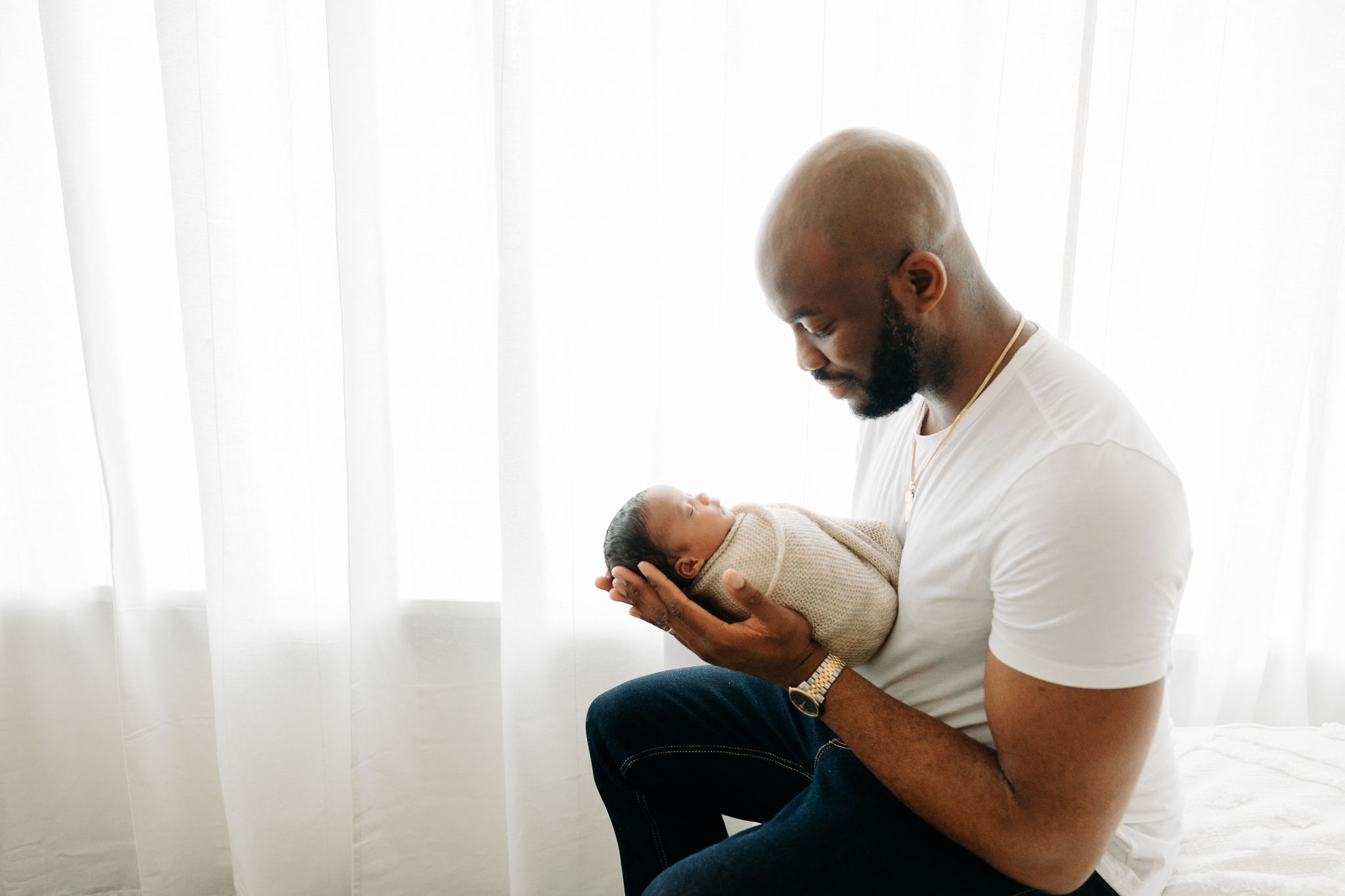 father holding his newborn baby son with white background