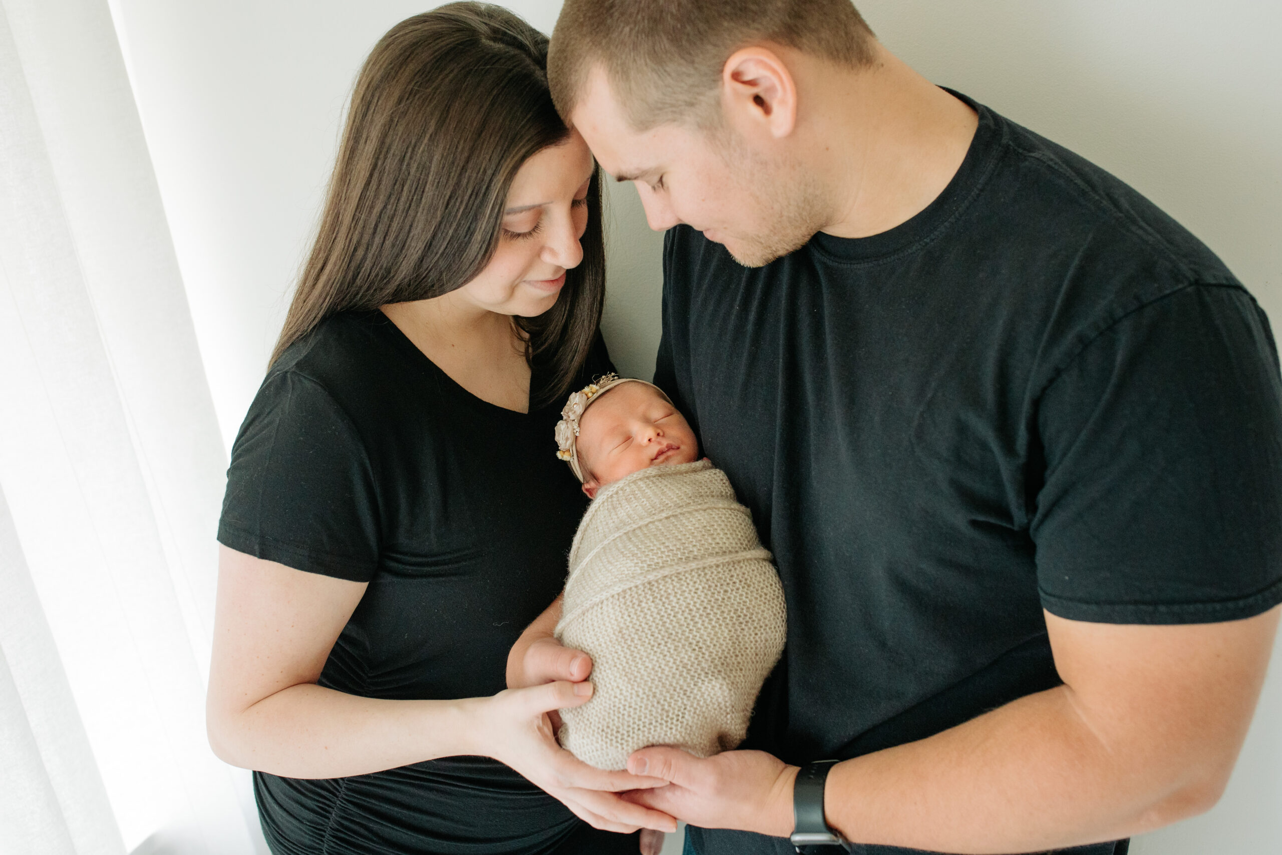 New parents in black for a studio family session with their newborn girl, captured by Kelly Adrienne Photography
