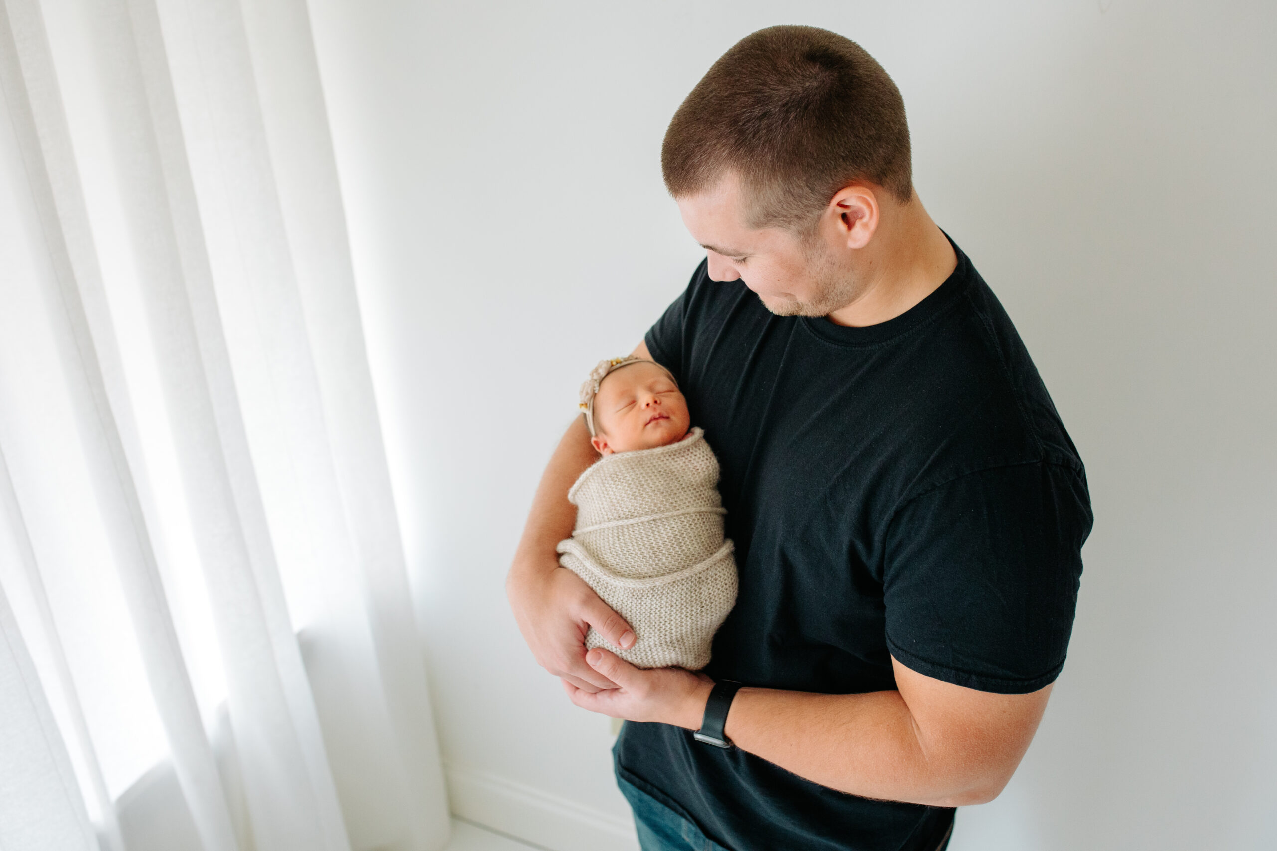 Dad with newborn baby girl in a studio family session with their newborn girl, captured by Kelly Adrienne Photography