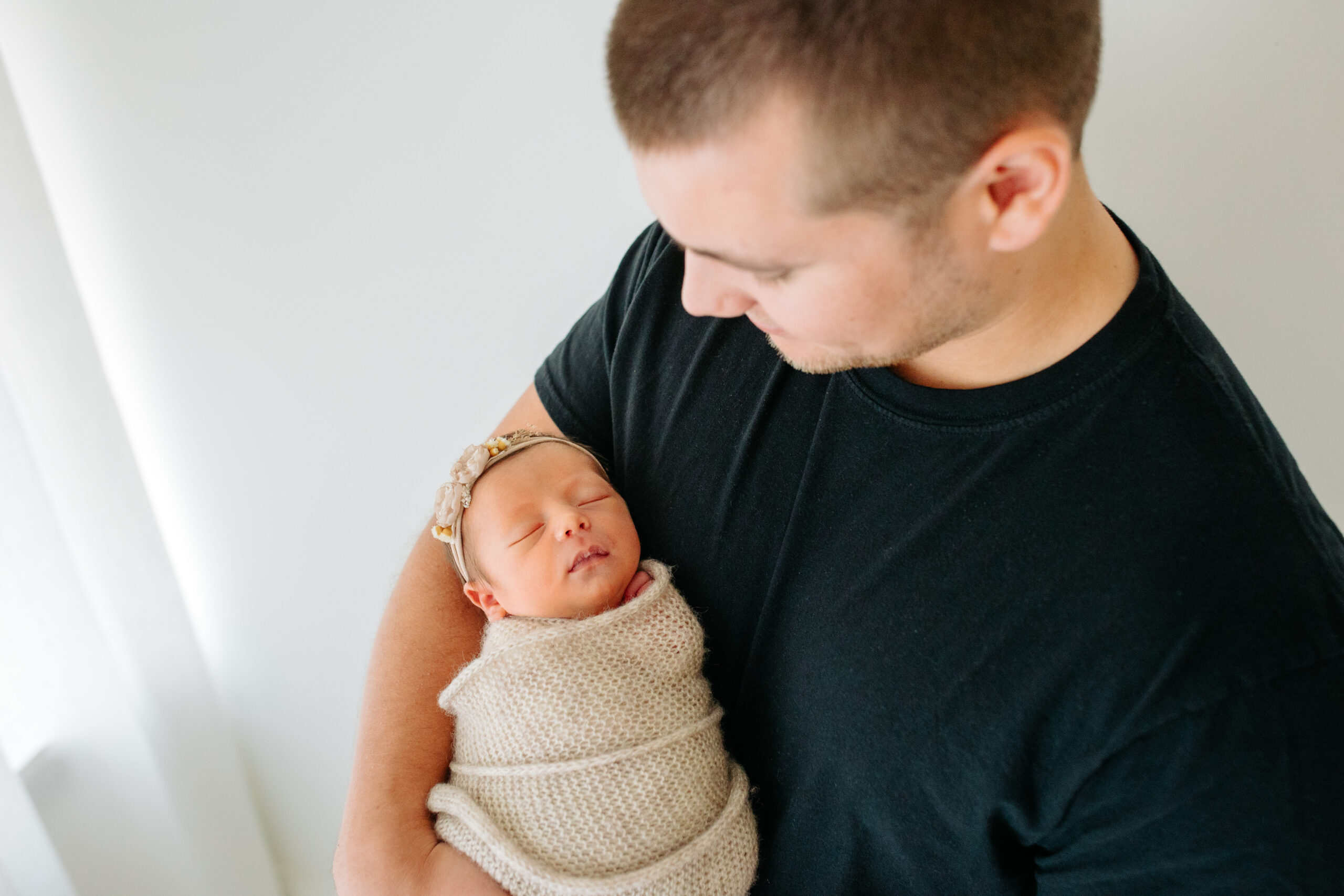 Dad with newborn baby girl in a studio family session with their newborn girl, captured by Kelly Adrienne Photography