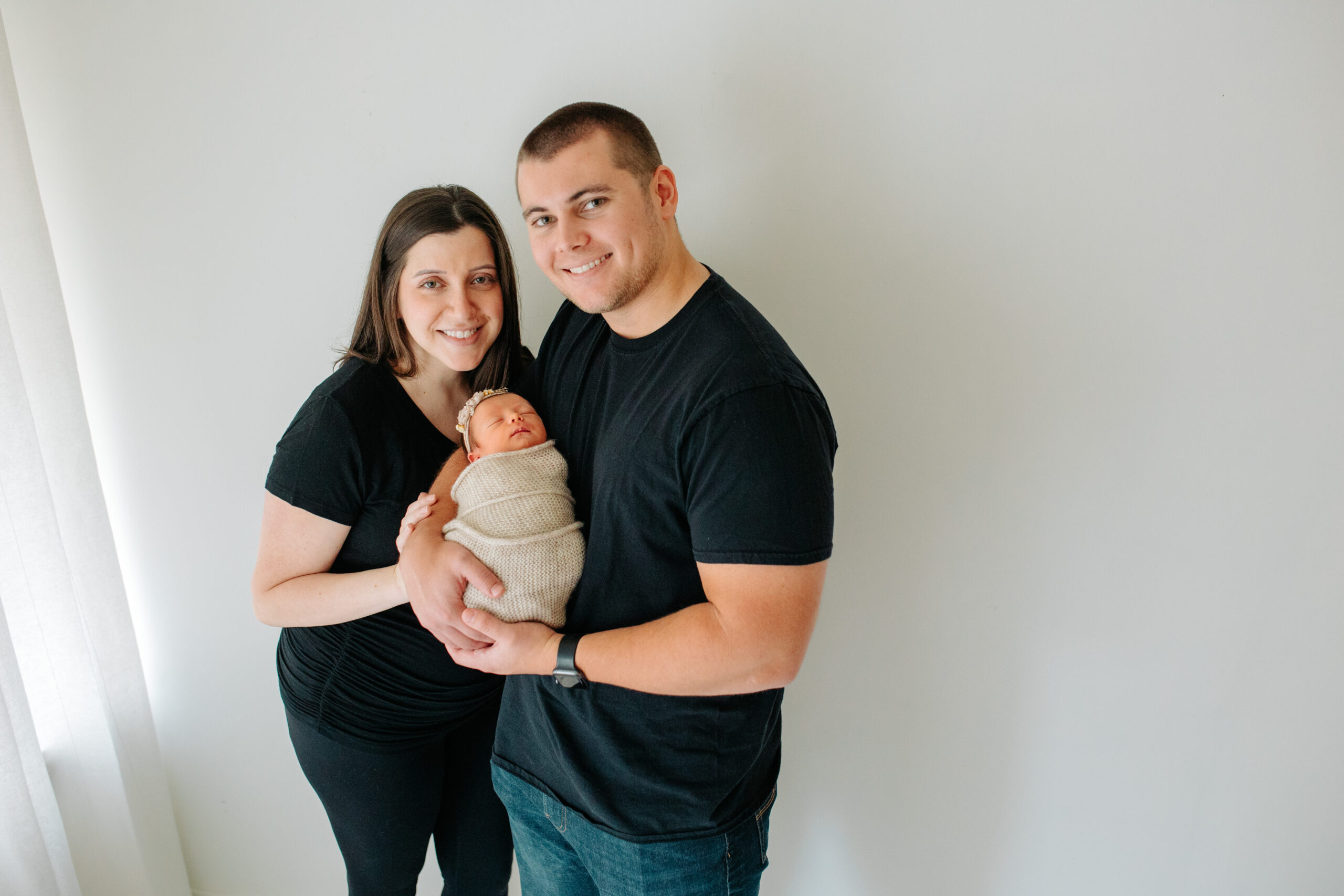 Ne parents  with newborn baby girl in a studio family session with their newborn girl, captured by Kelly Adrienne Photography