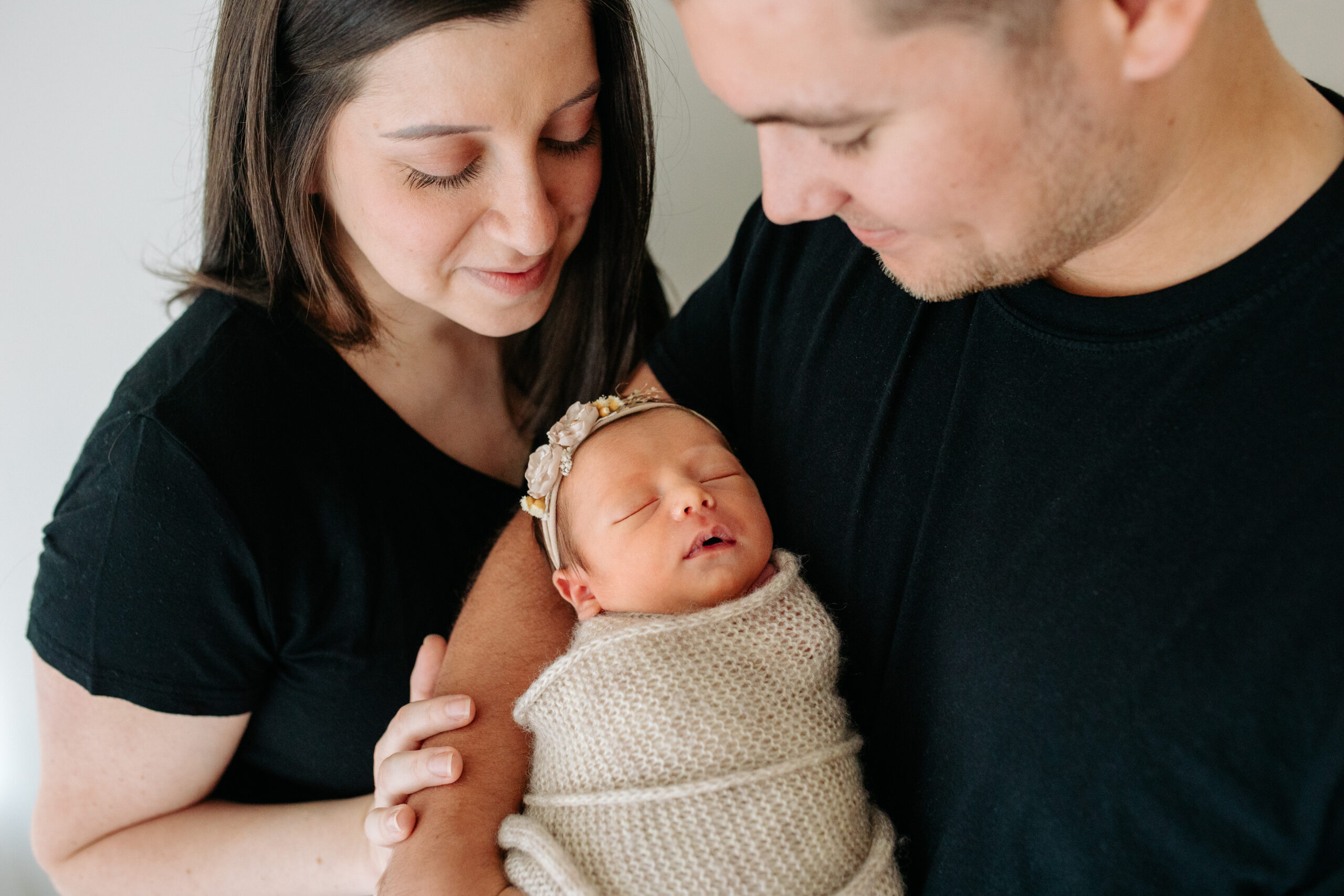 New parents with newborn baby girl in a studio family session with their newborn girl, captured by Kelly Adrienne Photography