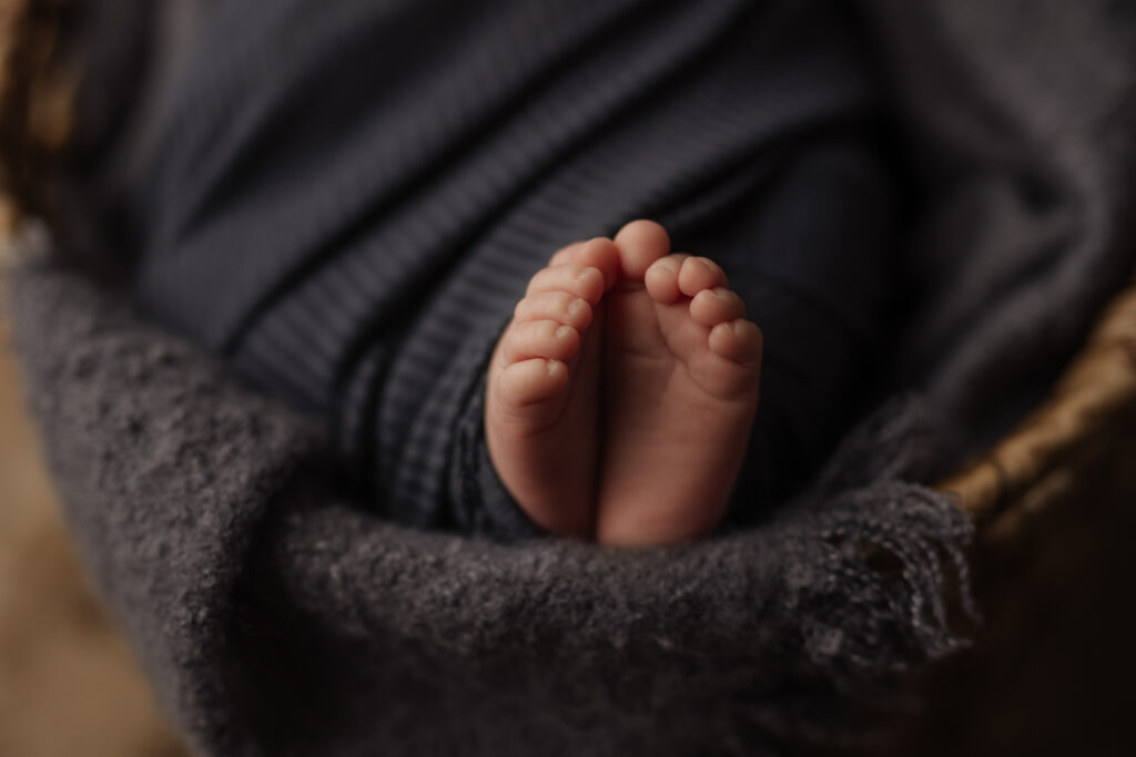 Closeup of baby feet wrapped in slate blue at Kelly Adrienne Photography studio 