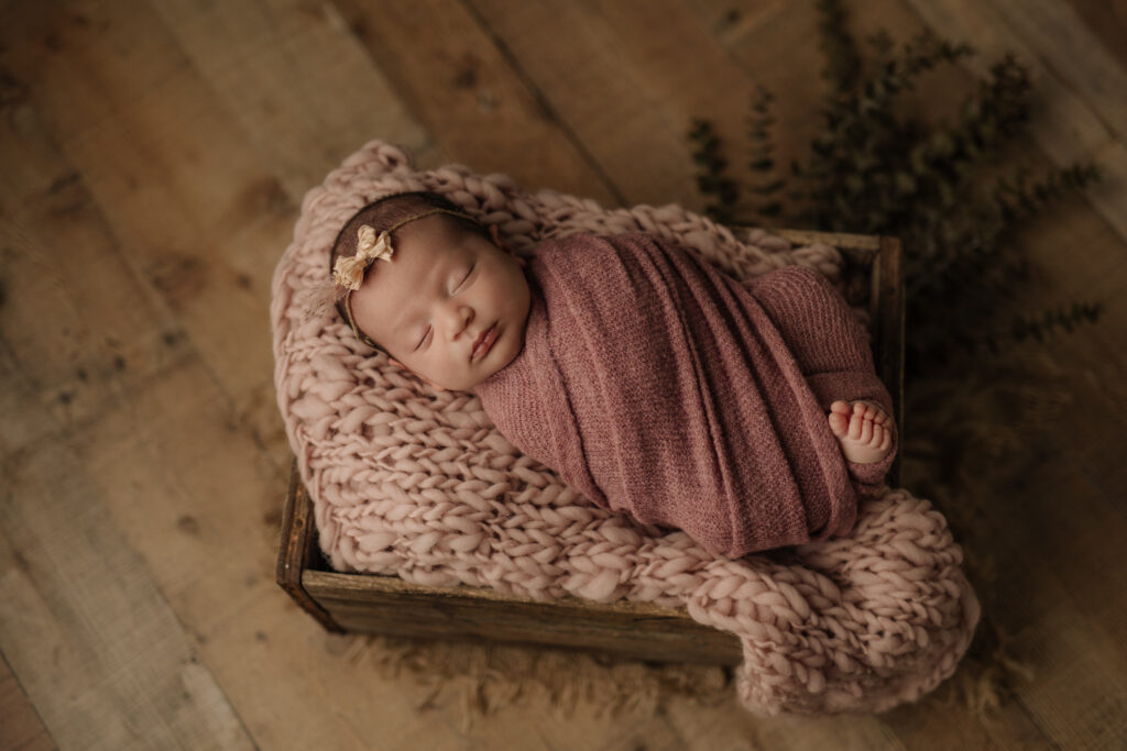 newborn girl lying on pink crochet blanket in crate prop - Kelly Adrienne Pittsburgh Newborn Photography studio