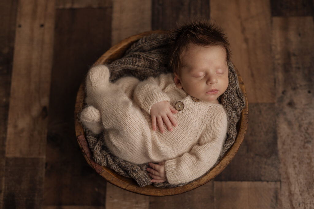 Newborn boy with lots of dark hair in neutral jammies at Kelly Adrienne Pittsburgh Newborn Photography