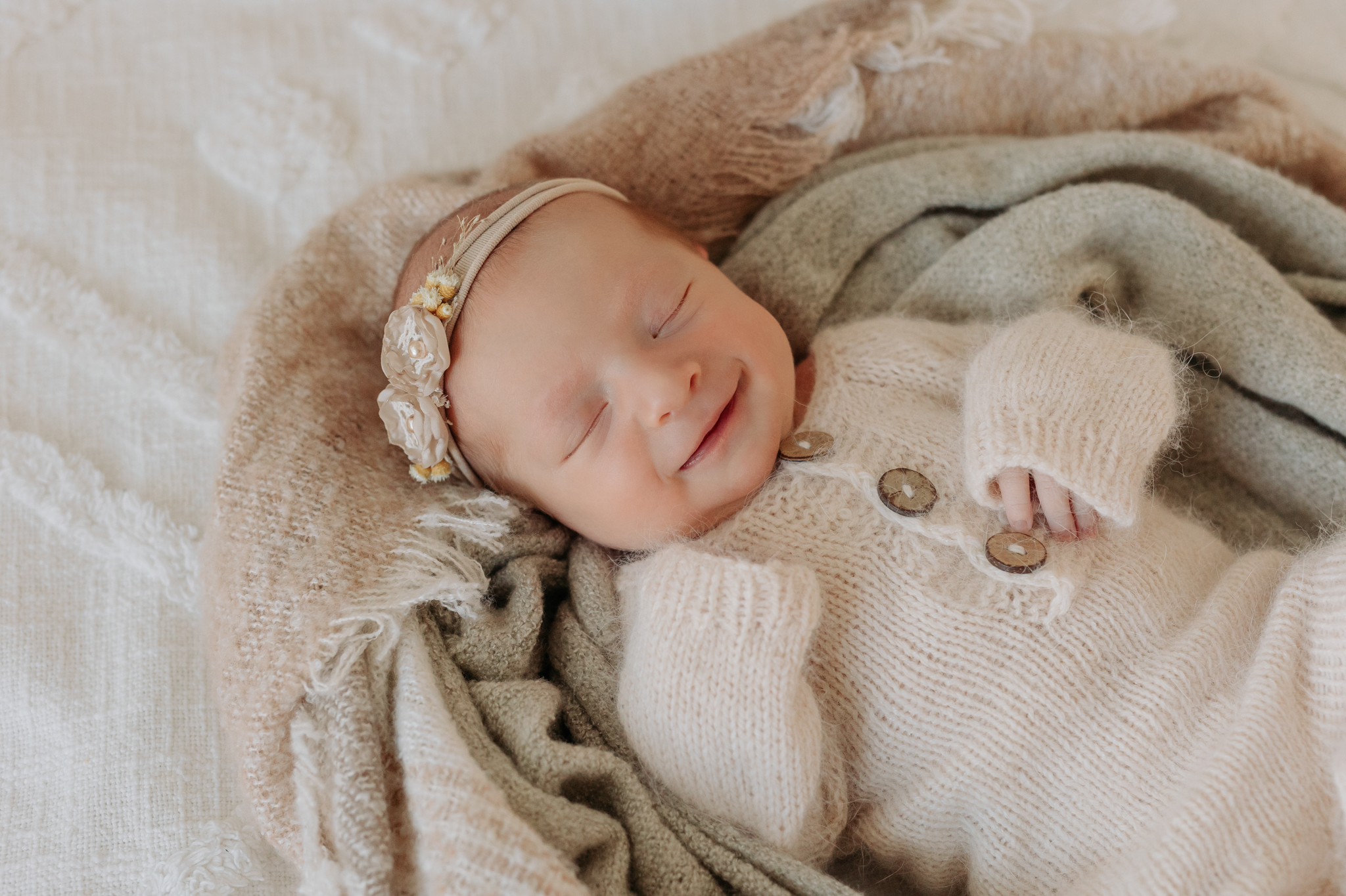 Natural newborn setup with baby in cream pajamas
