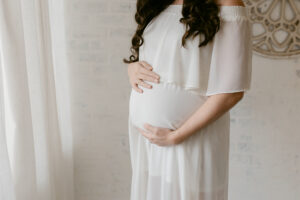 Indoor maternity session, white studio, white dress
