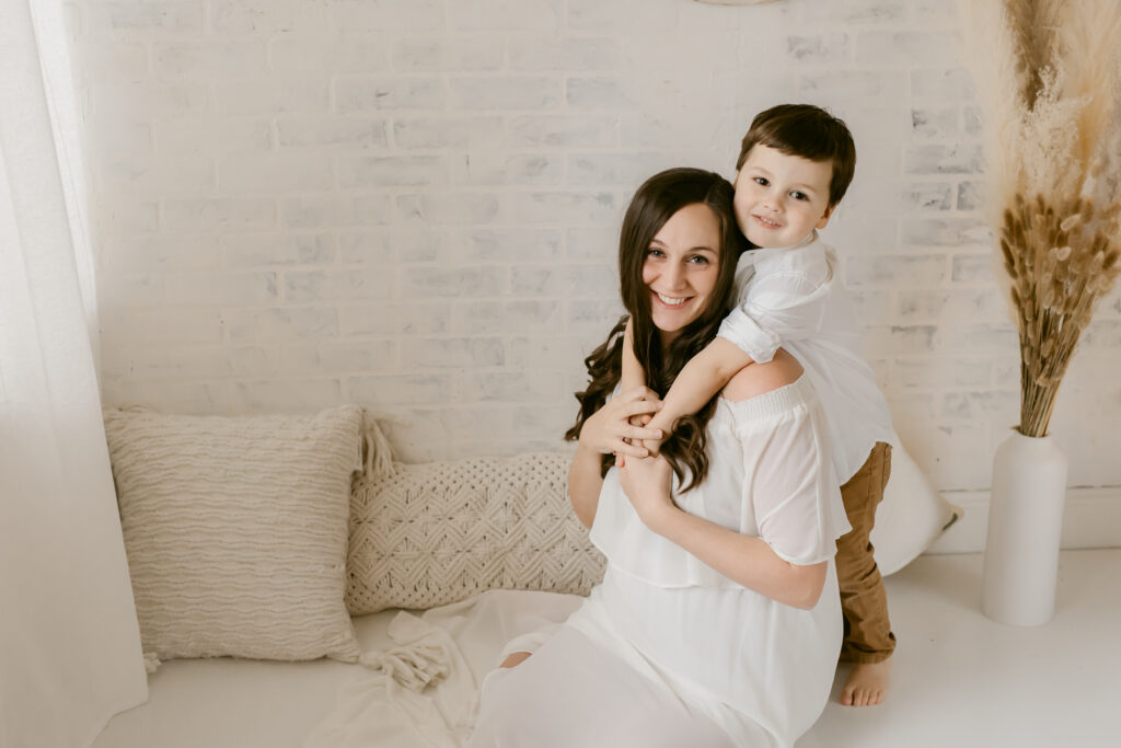 Indoor maternity session, white studio, mother and son