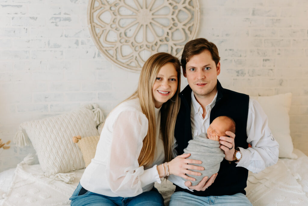 mom, dad, and baby snuggling at boho newborn session
