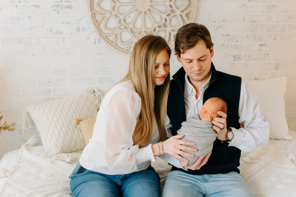 mom, dad, and baby snuggling at boho newborn session