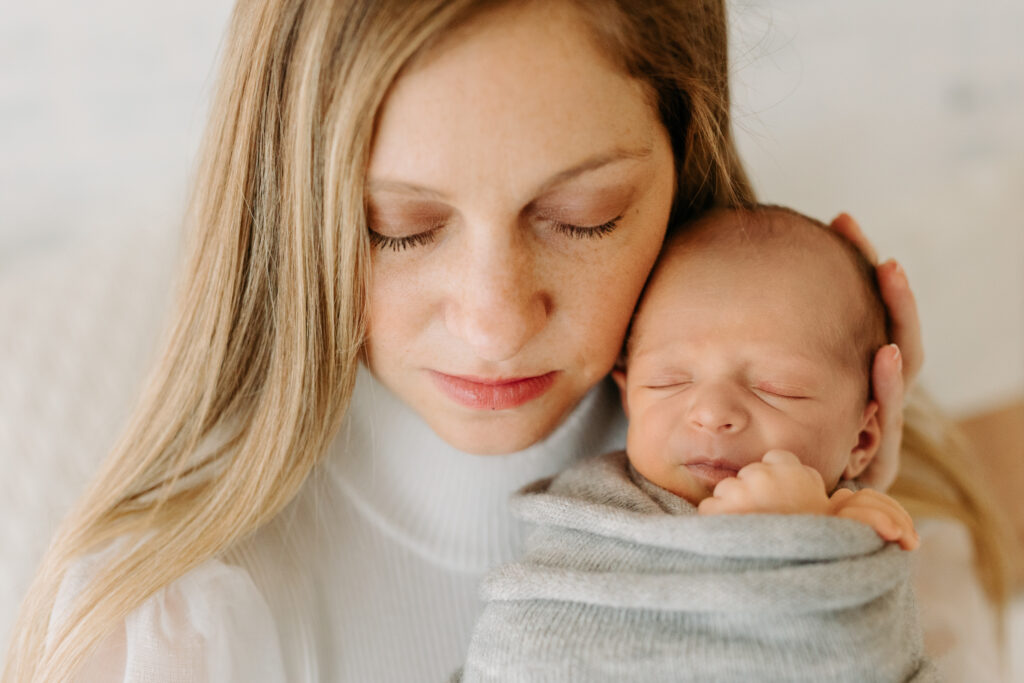 close-up of mom and baby snuggling at newborn session