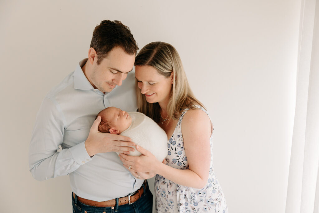 Parents and newborn at all white studio setup | Kelly Adrienne Photography