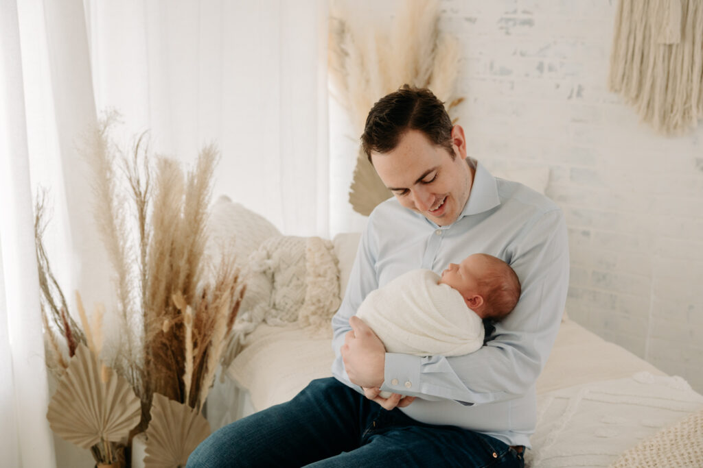 Dad looking down at newborn baby at boho family session | Kelly Adrienne Photography