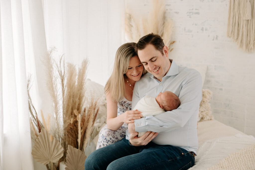 Parents looking down at newborn baby at boho family session | Kelly Adrienne Photography