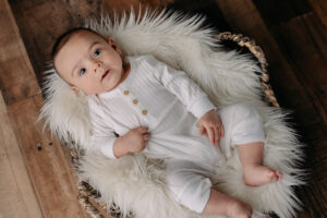 3-month old studio session | baby boy in white pajamas lying on fur