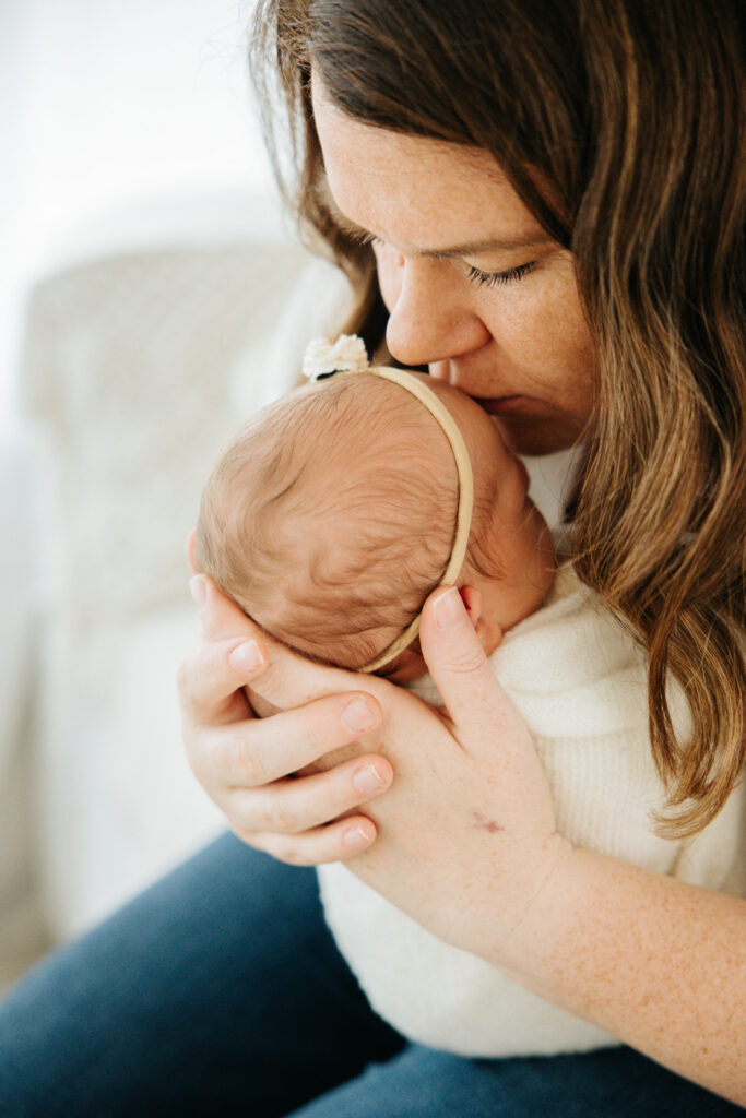 Mom kissing baby's head at newborn photo session | Kelly Adrienne Photography 