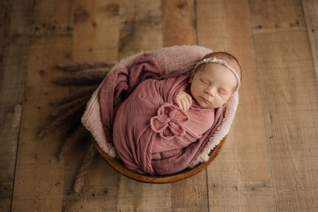 Newborn girl photos with mauve wrap and florals 