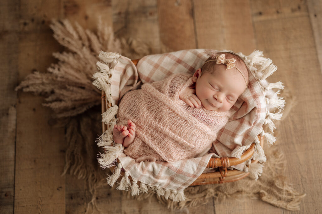 Newborn photos done in Wexford PA using cream and pink accessories and floral props