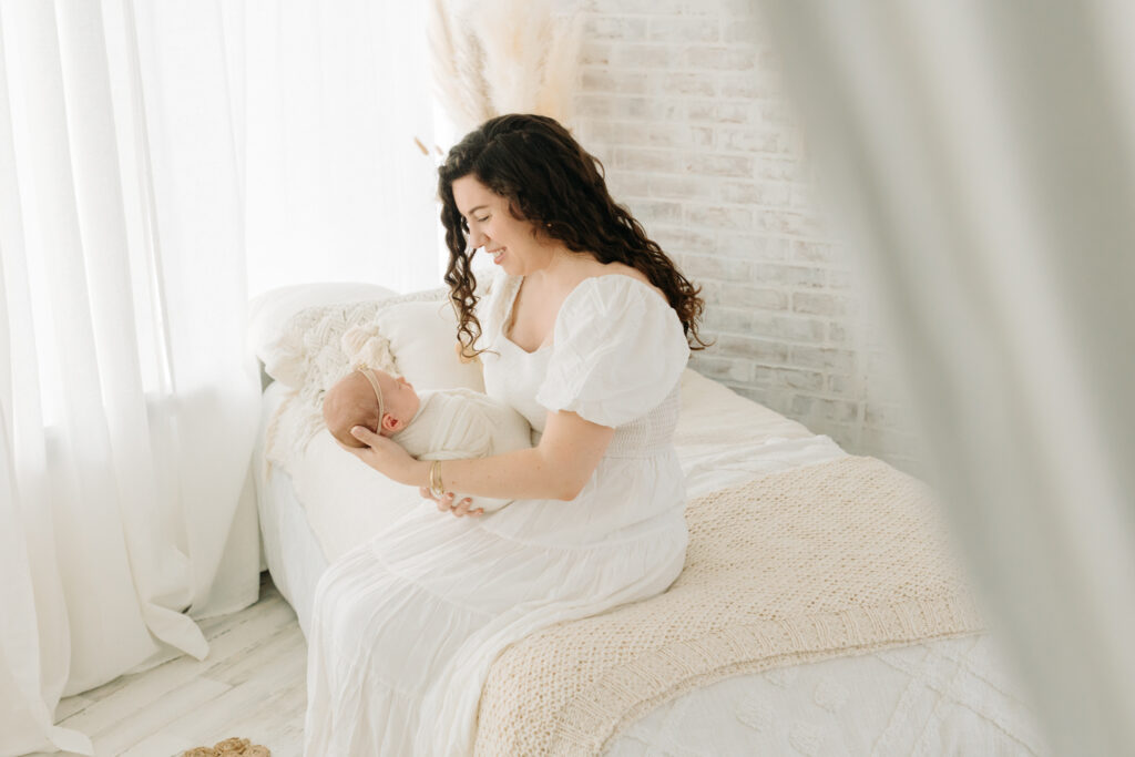 mom holding newborn daughter at photo studio in Pittsburgh