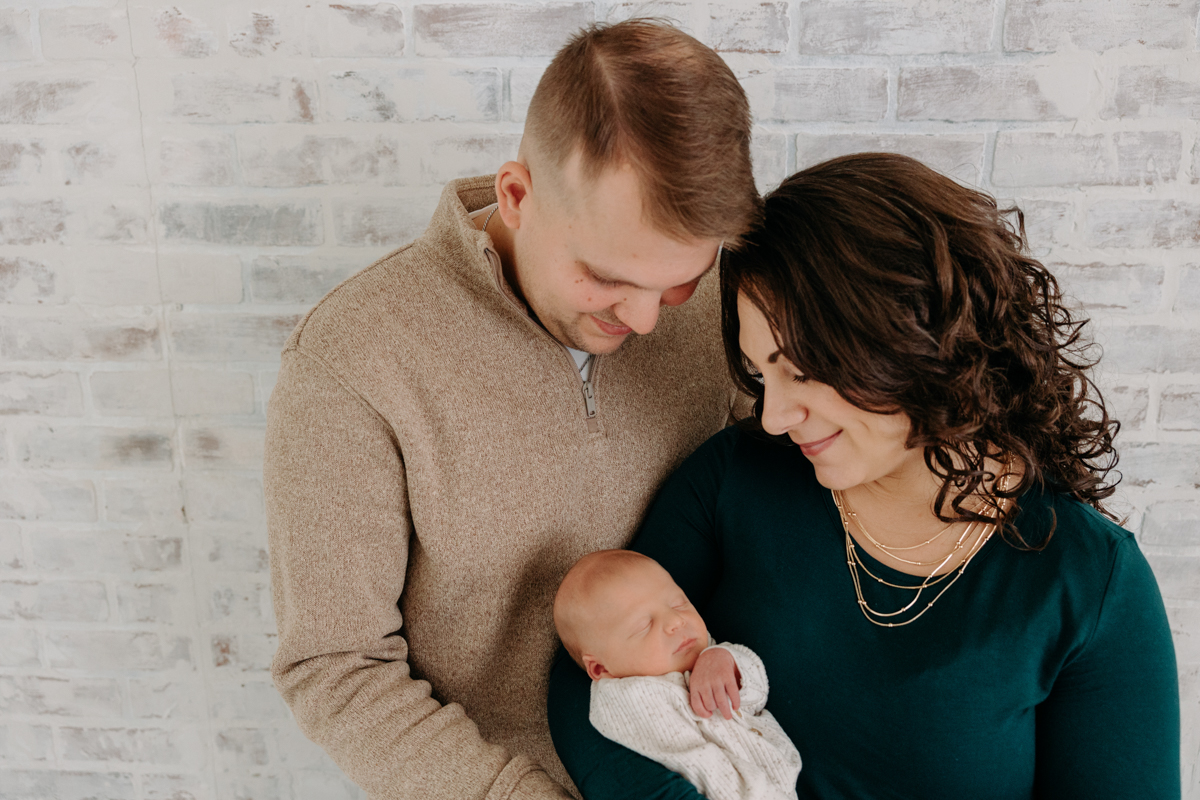 mom and dad with newborn baby at large family newborn session