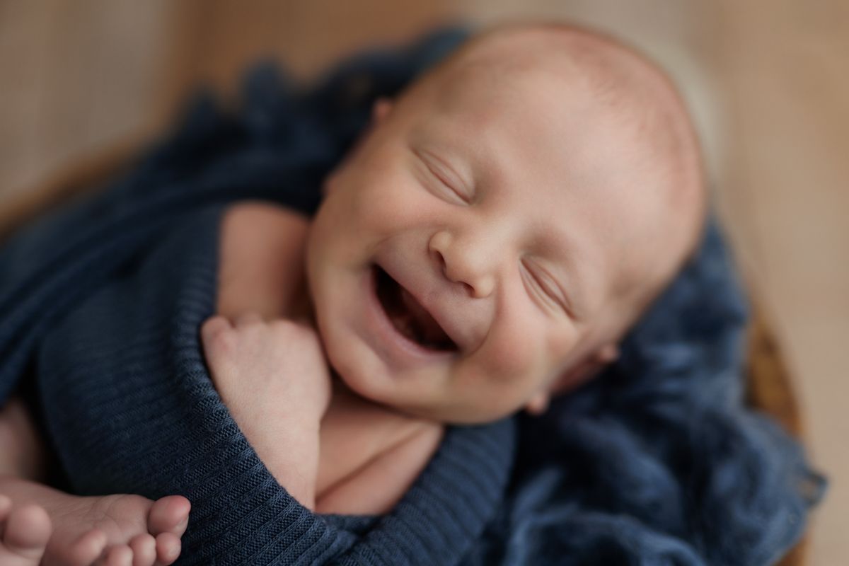 newborn boy laughing in blue at Pittsburgh newborn photo shoot