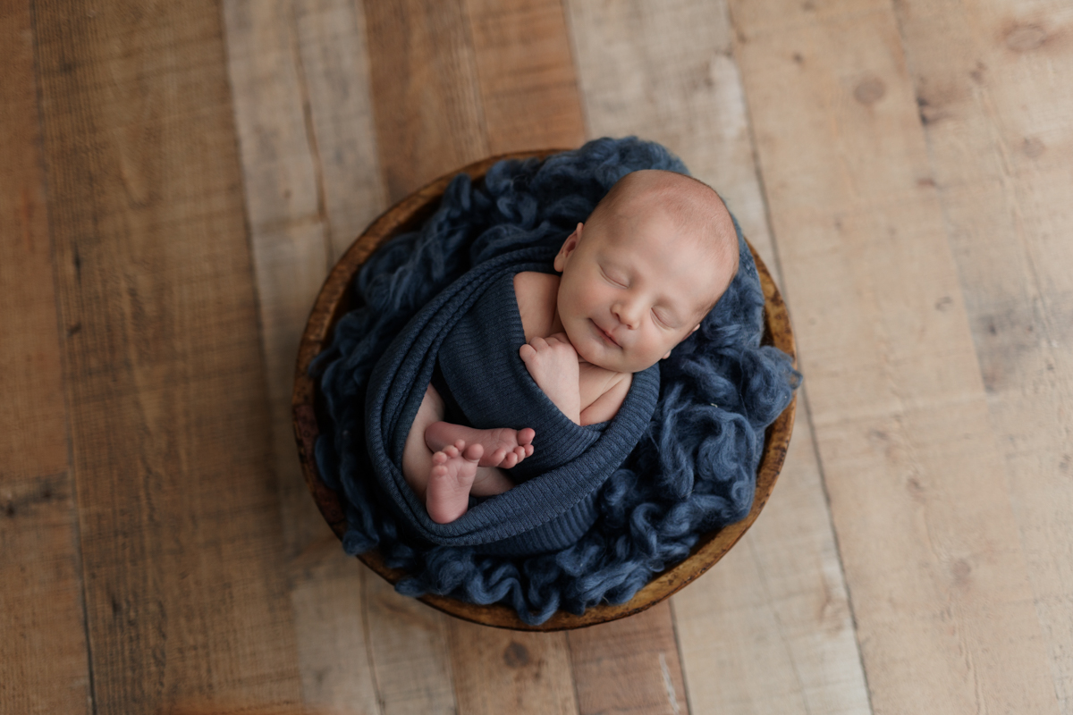 baby boy in blue in bowl prop at Pittsburgh newborn photo shoot