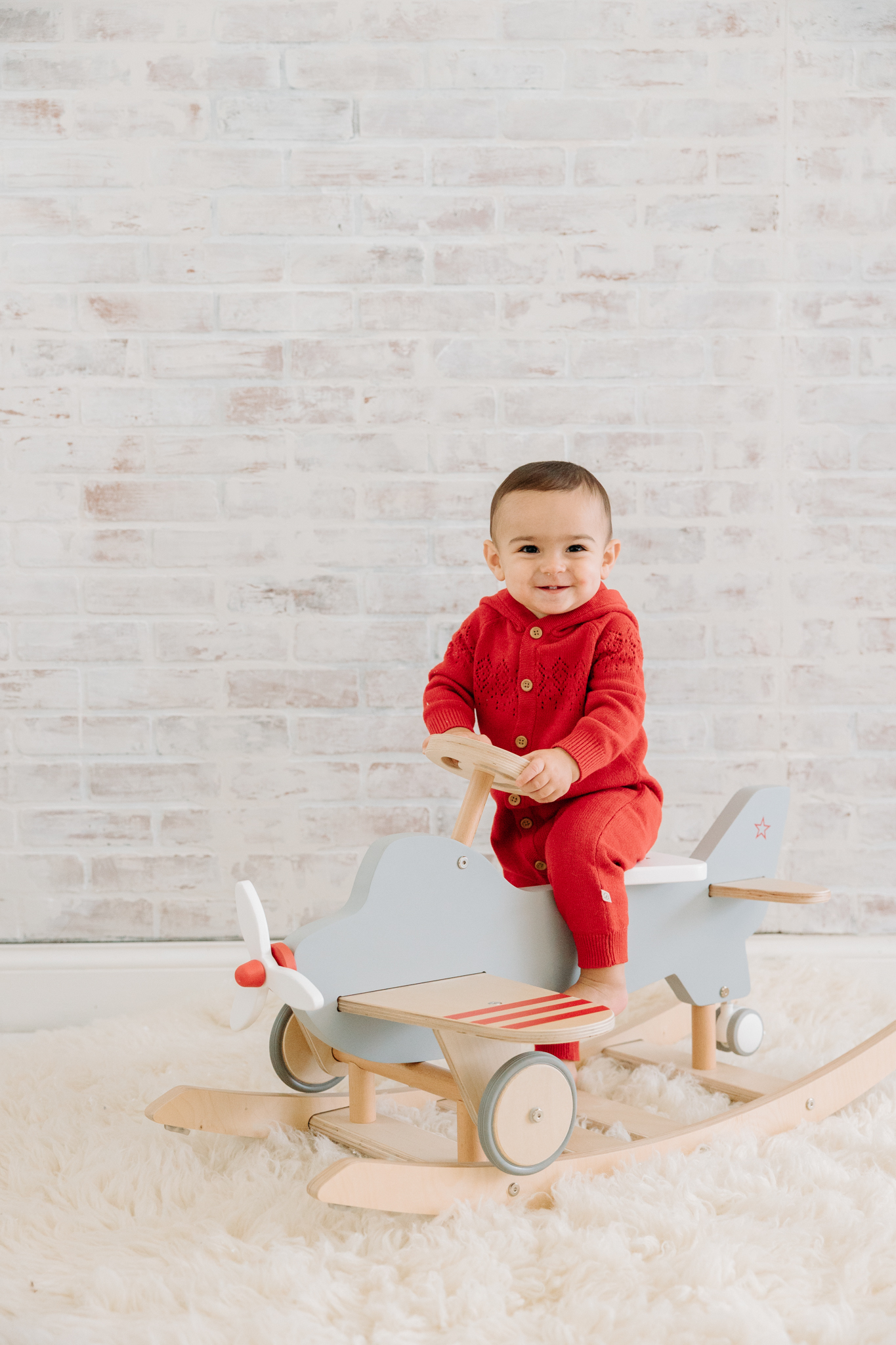 one-year-old with toy airplane rocker at photoshoot at Kelly Adrienne Photography 