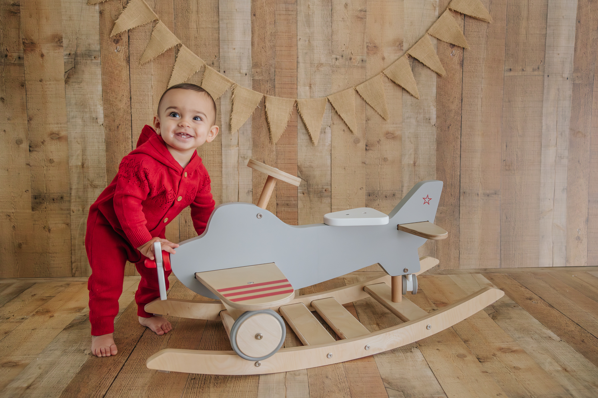 one-year-old with toy airplane rocker at photoshoot at Kelly Adrienne Photography 