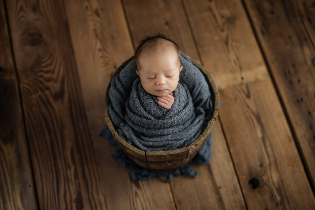 boy wrapped in blue in wooden bucket | Kelly Adrienne Photography