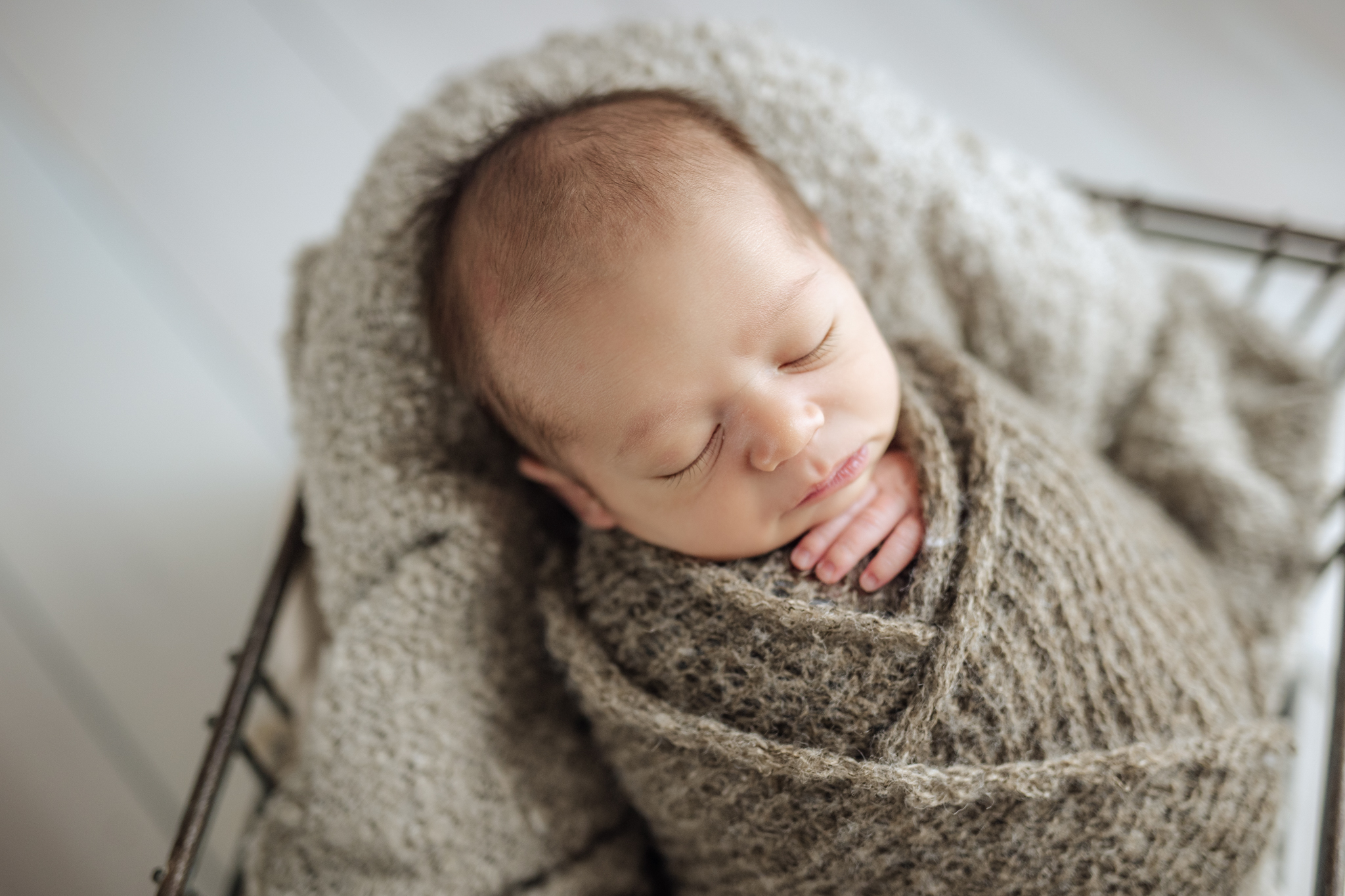 A boy wrapped in beige at his newborn photo shoot in Pittsburgh
