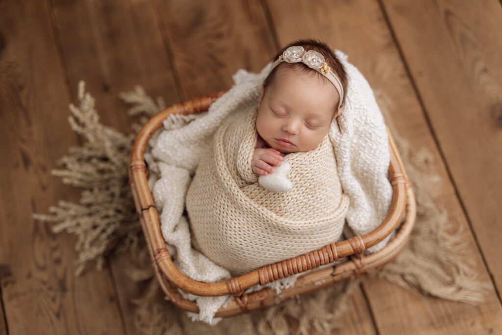 newborn holding heart prop at newborn photo shoot 