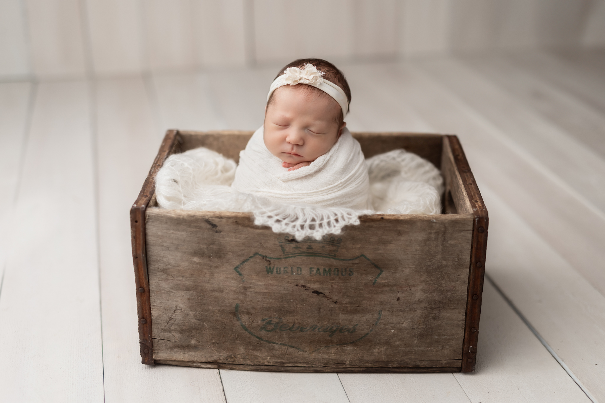 newborn posed in crate at photo shoot 