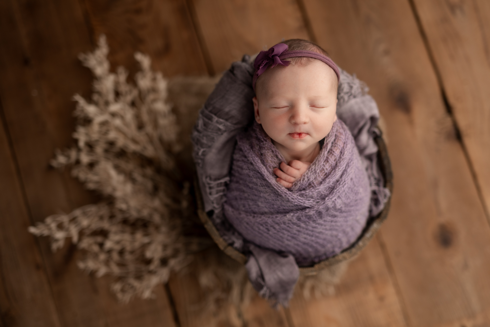 newborn girl in purple in prop at newborn session in Pittsburgh