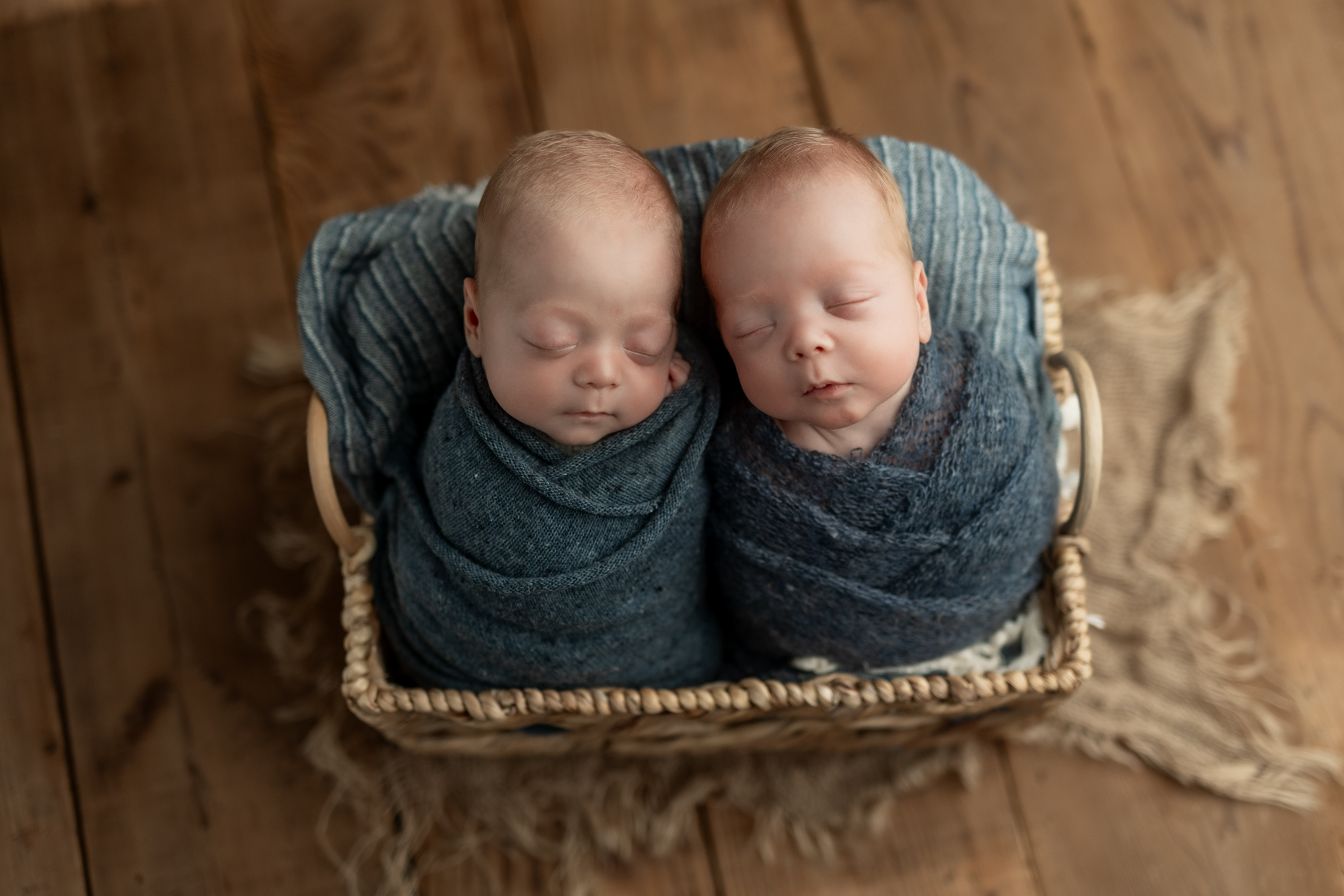 newborn twin photography ideas including this basket set up with boys in blue