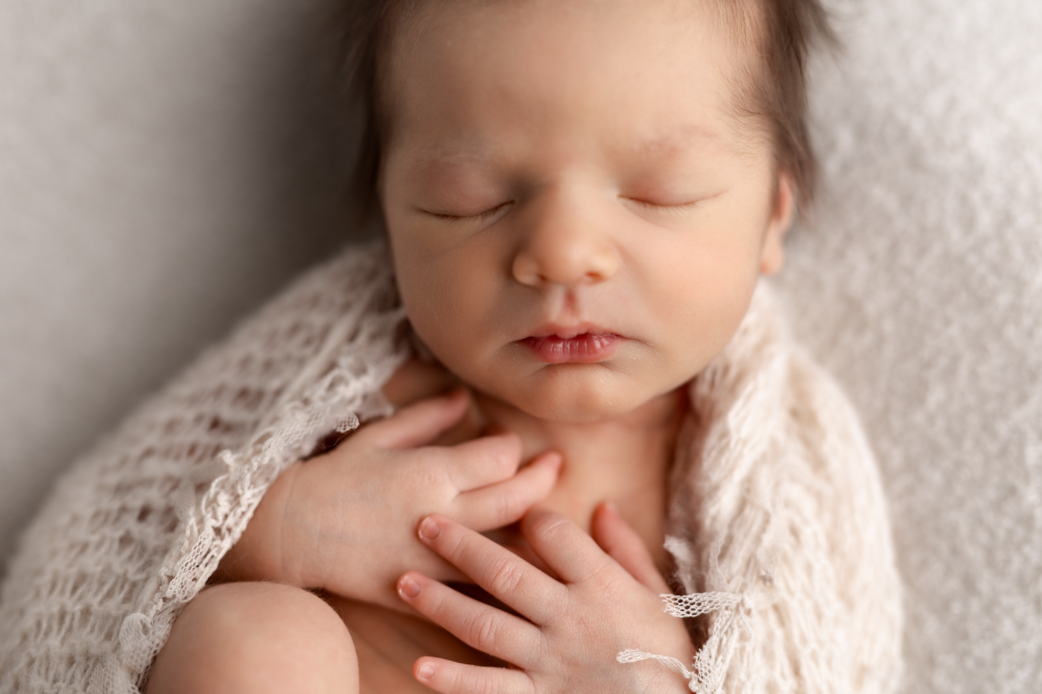 Sleeping newborn baby wrapped in a neutral swaddle