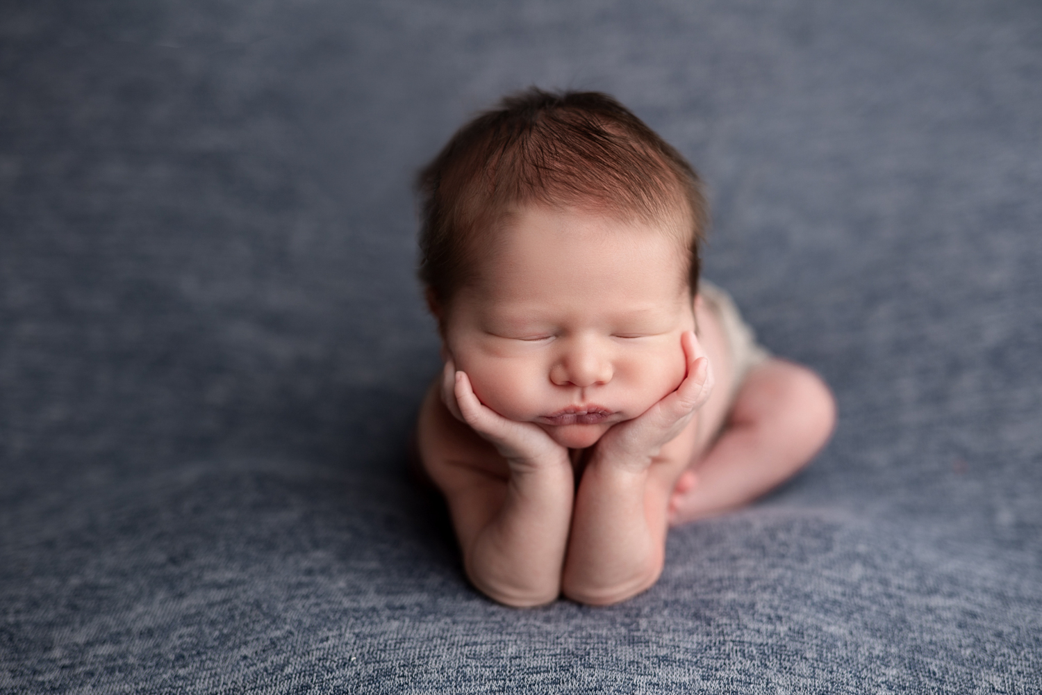 the value of newborn photography, baby on blue fabric